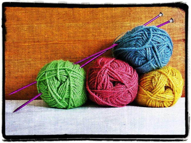 Coloured balls of wool and knitting needles to illustrate the health benefits of knitting