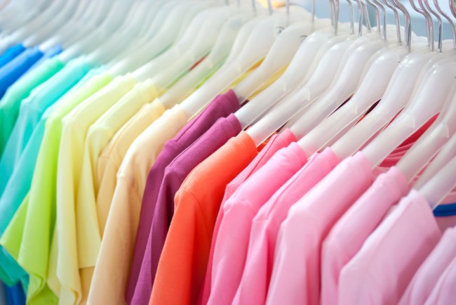 A rack of T-shirts organised by colour
