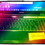 laptop computer with a note saying breathe on it
